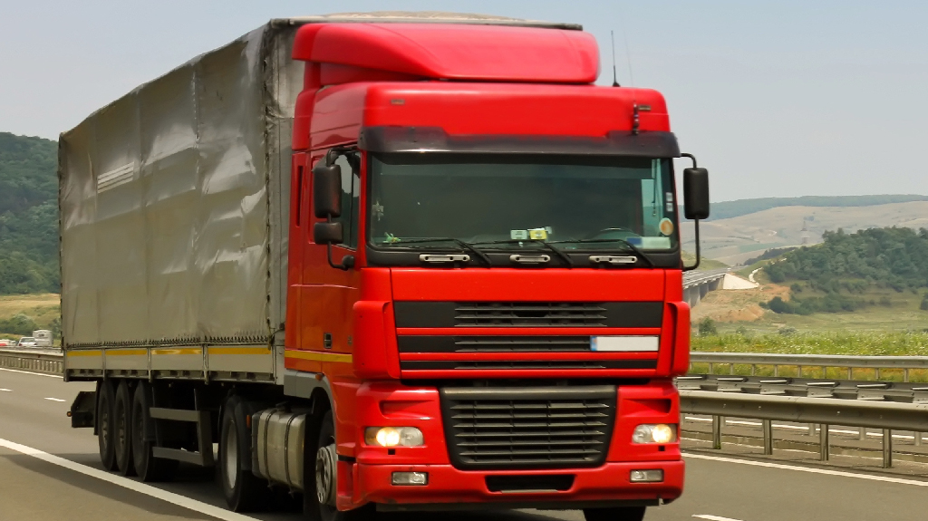 Road freight truck transporting commercial cargo for road freight customs clearance at UK border and customs entry processing